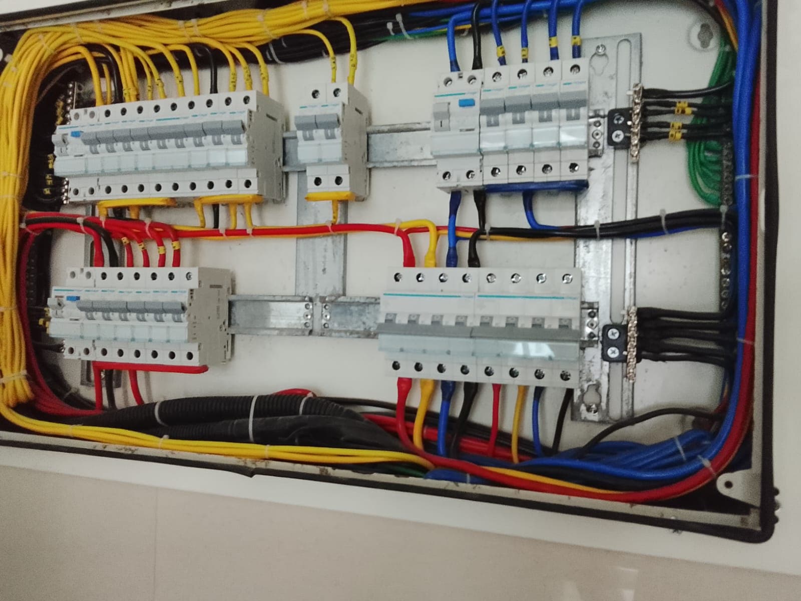 Colour-coded wiring terminated onto a row of MCBs inside a Yash Power Tech distribution board